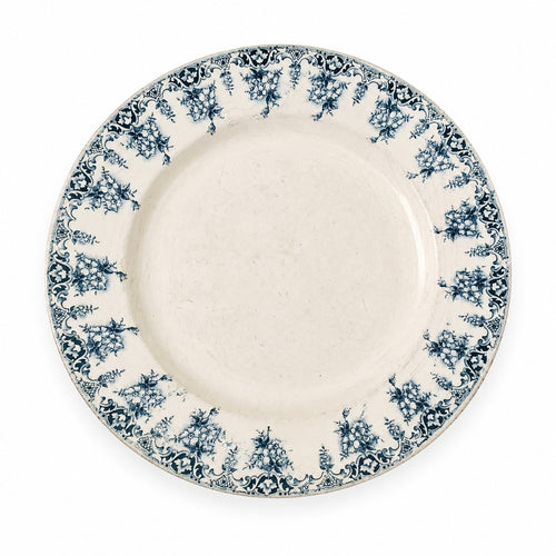 Assiette creuse ancienne en terre de fer modèle Primevère, décor floral bleu, commercialisée pour les Nouvelles Galeries à la fin du XIXᵉ siècle.