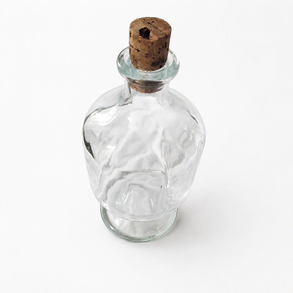 Bouteille ancienne en verre sur pied