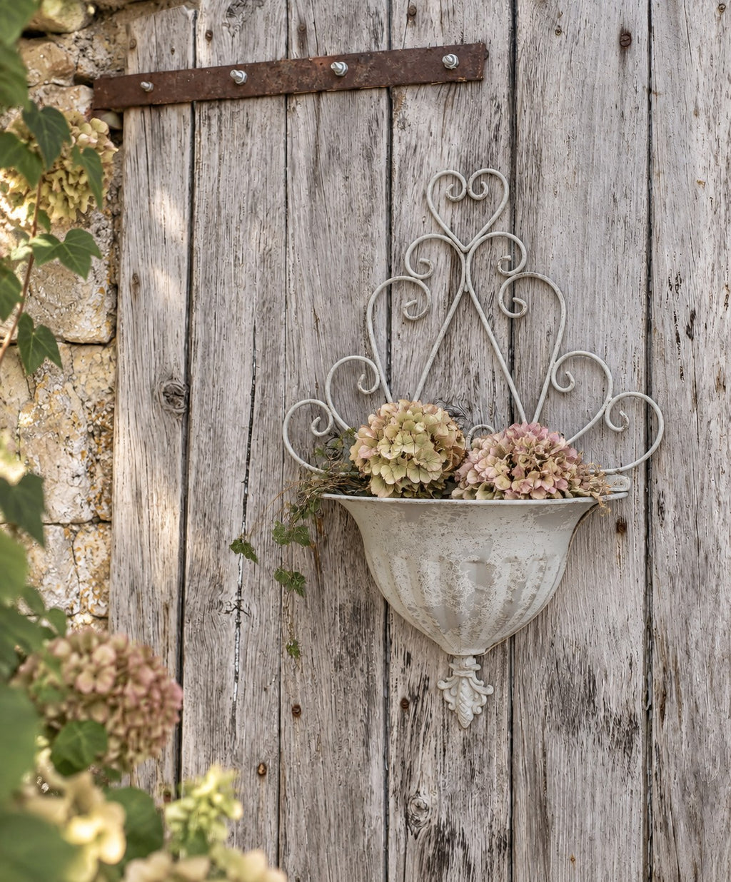 Cache-pot mural en métal gris patiné pour fleurs et plantes, décoration romantique et maison de caractère.