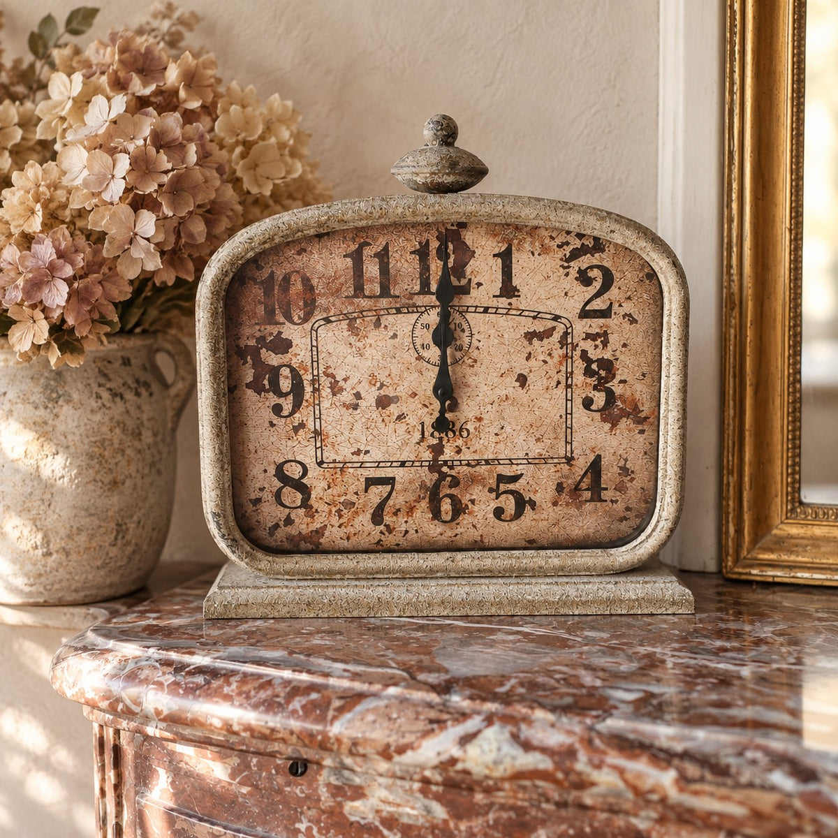Horloge décorative à poser en métal finition patinée, idéale pour une maison de famille ou une décoration de caractère.