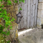 Lanterne en métal et verre plantée dans un jardin, ambiance chaleureuse campagne chic
