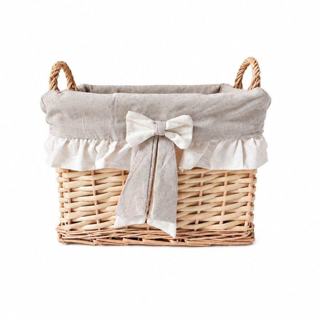 Panier rectangulaire en osier avec doublure en tissu écru et grand nœud décoratif, esprit maison de famille.