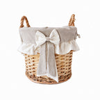 Panier rond en osier avec doublure en tissu naturel, volant et nœud décoratif.