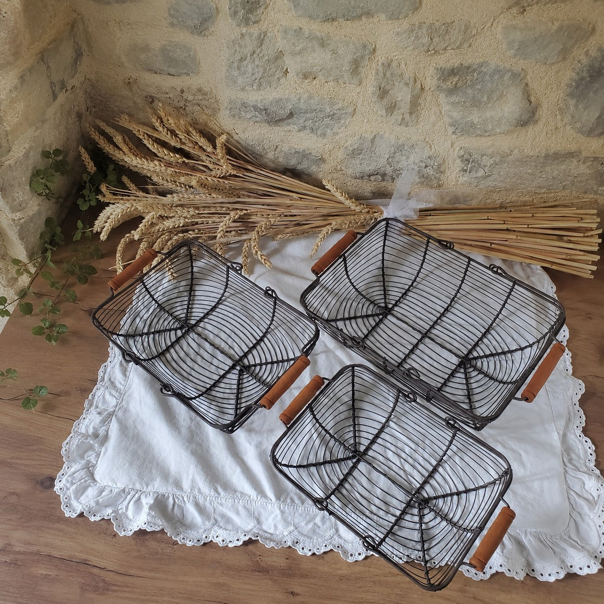 Panier de rangement en métal avec poignée en bois, corbeille ajourée pour organiser et décorer la maison.